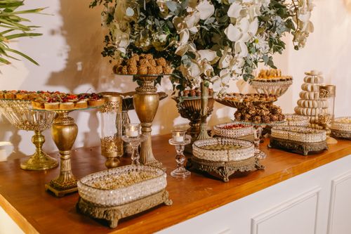 Free Elegant dessert table with luxurious floral arrangements and ornate platters. Stock Photo