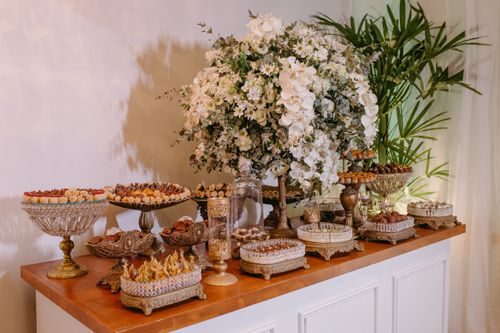 Free A beautifully arranged dessert buffet with ornate floral decorations on a wooden table, perfect for celebrations. Stock Photo