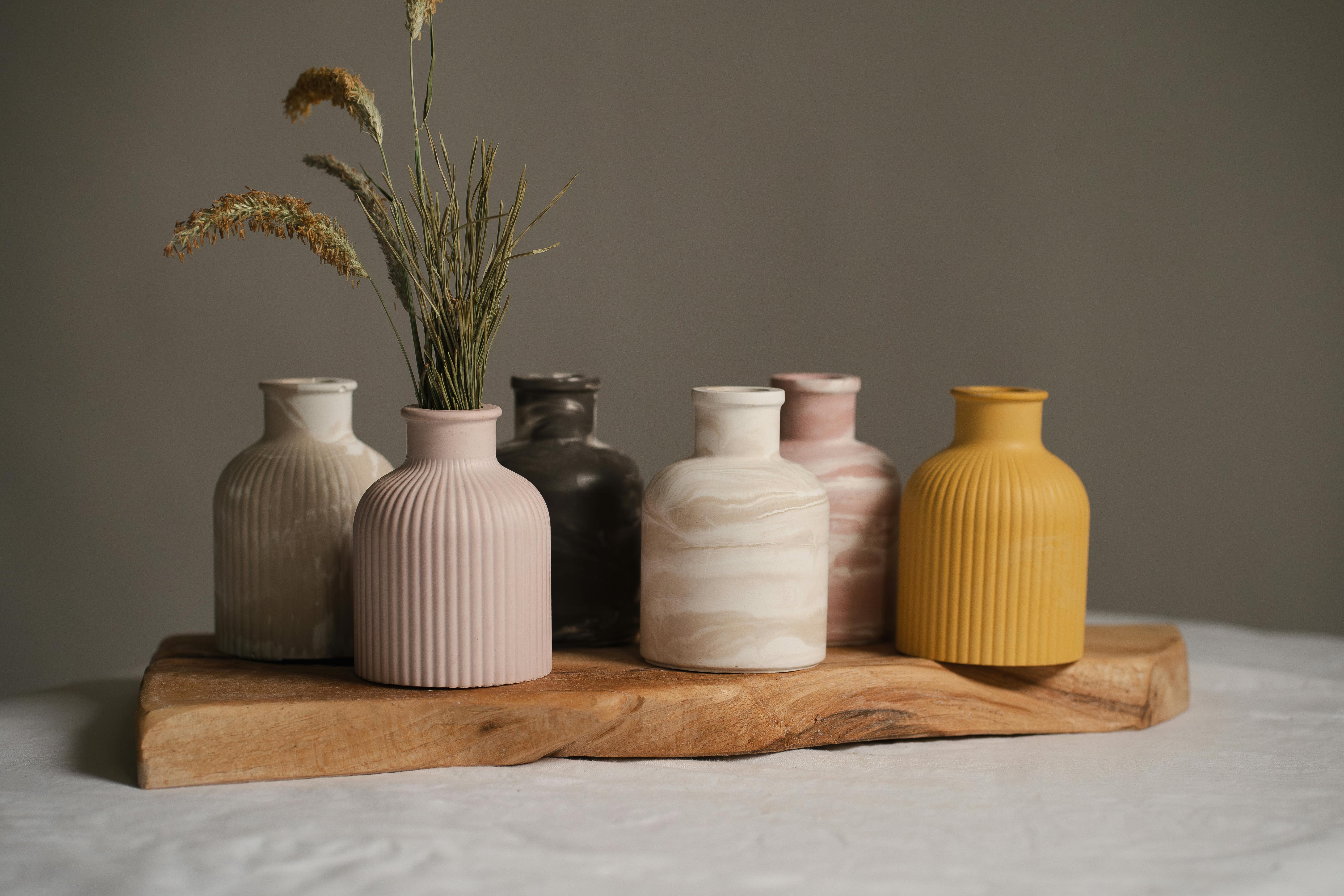 Aesthetic display of minimalist ceramic vases on a wooden tray, perfect for home decor.