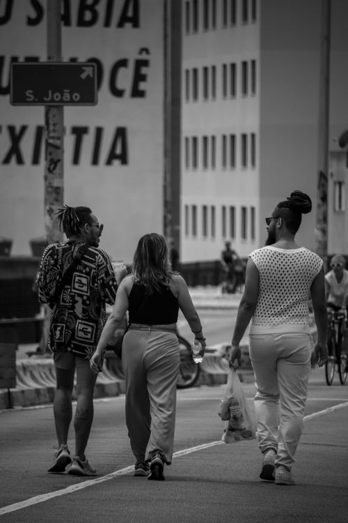 Free Group of people walking in a city street, captured in black and white, with an urban backdrop. Stock Photo