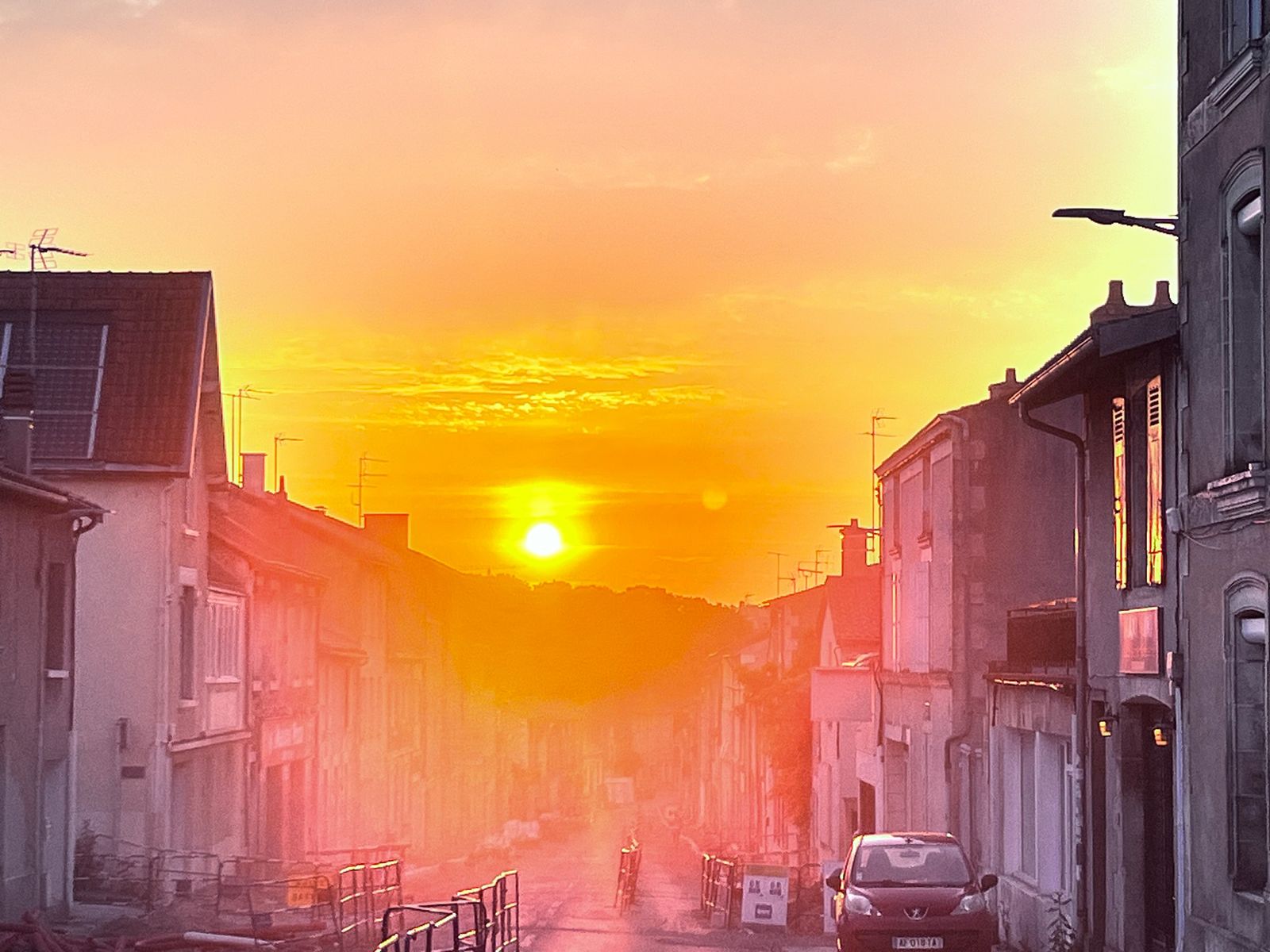 Coucher de soleil orange flamboyant au bout d'une rue