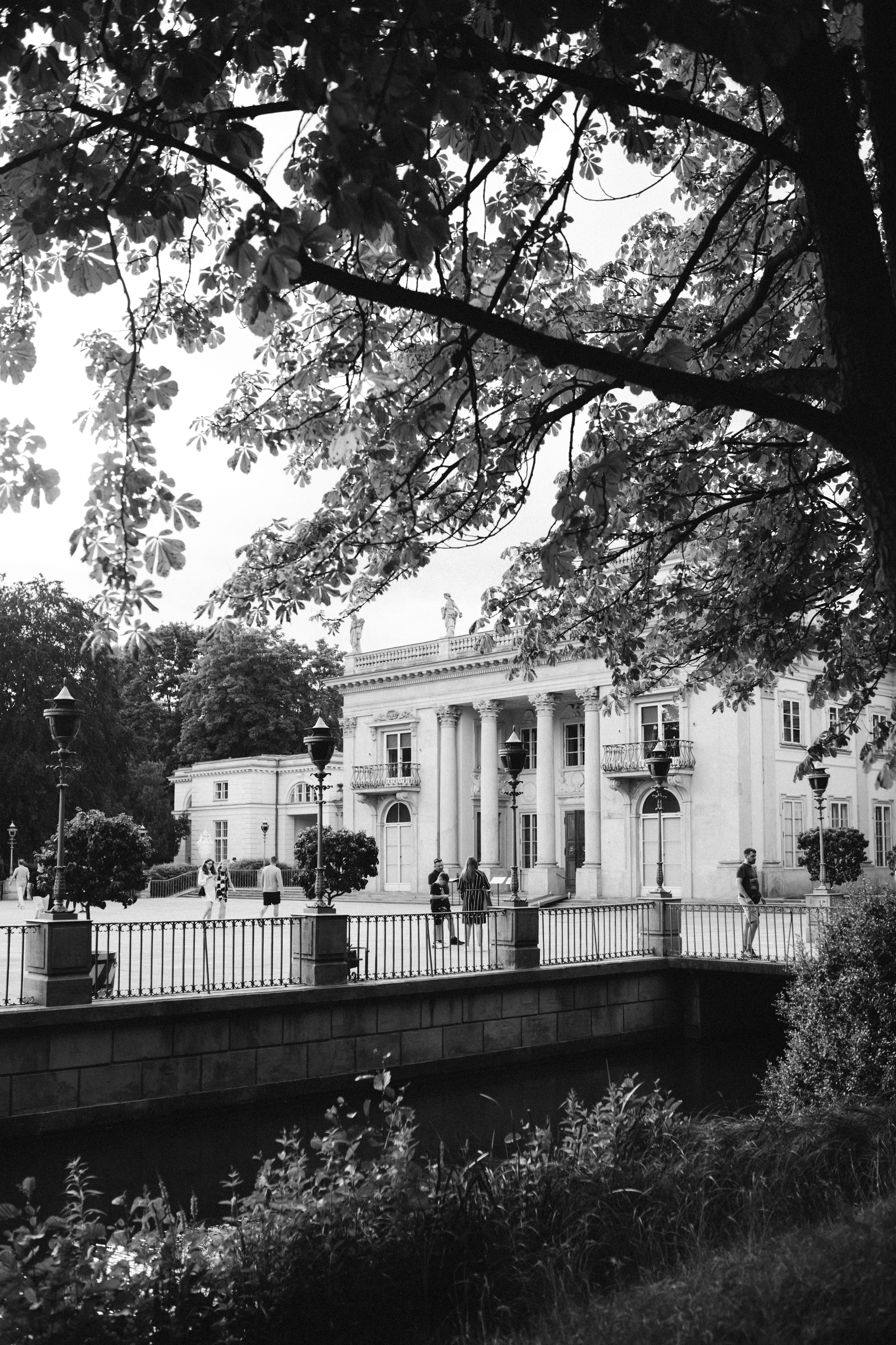 Black and white photo of Warsaw's Palace on the Isle and surrounding scenery.