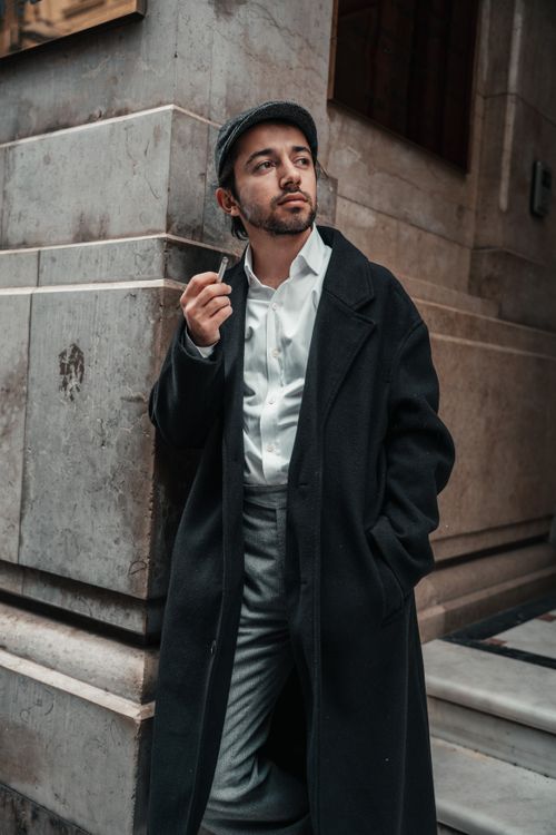 Free Man in a coat and hat posing in İstanbul, showcasing urban fashion style. Stock Photo