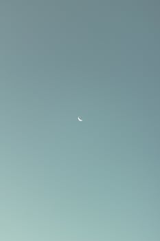 黄昏时分，一弯宁静的新月高悬于晴朗的天空，景色怡人