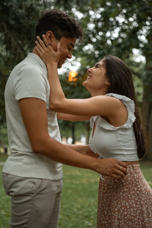 Free A happy couple sharing a loving moment outdoors in a sunny park setting. Stock Photo