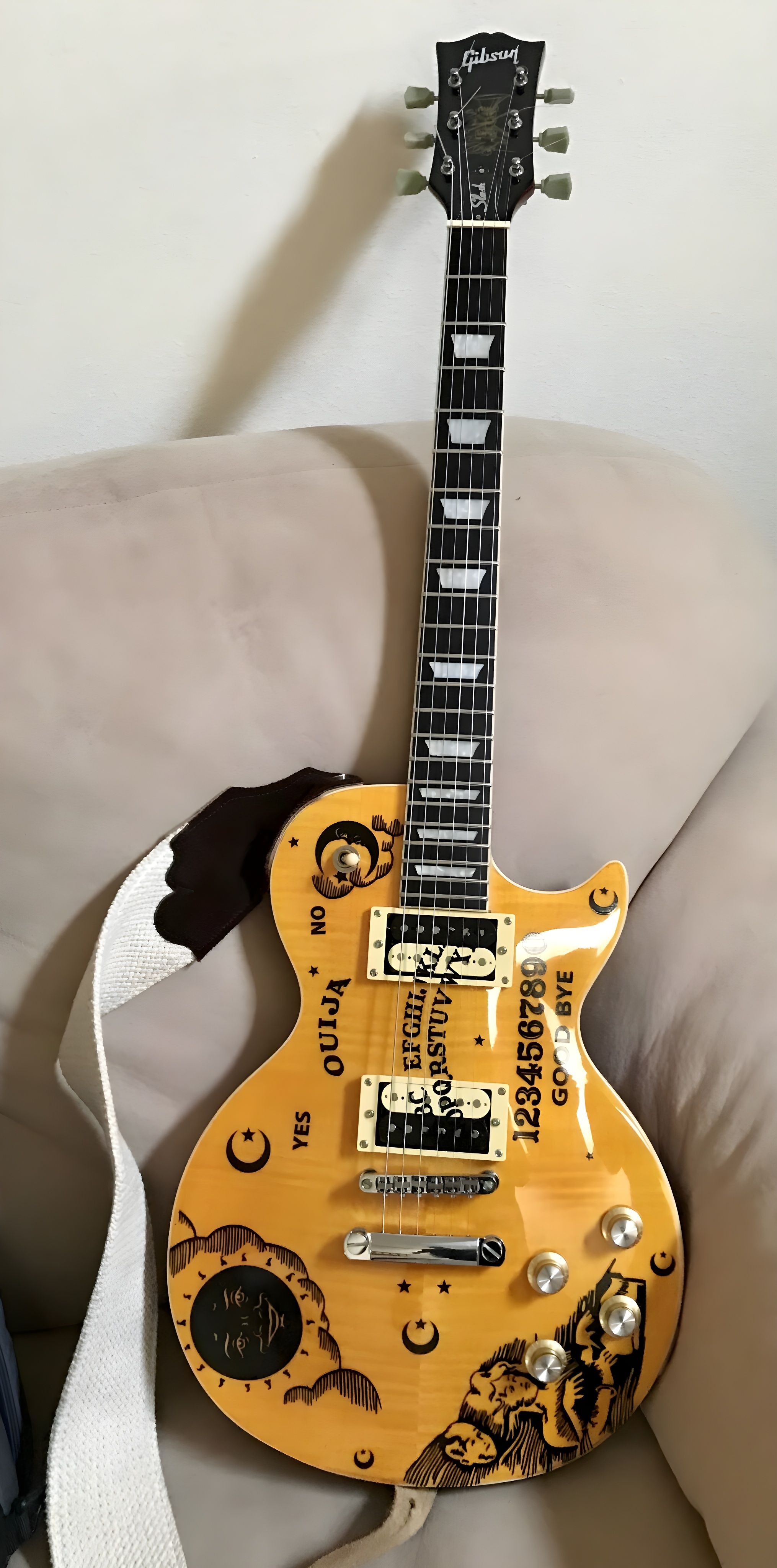 Electric guitar featuring unique Ouija board design, great for rock music enthusiasts.