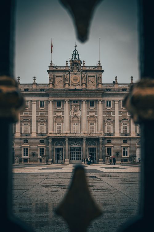 Free View of the Royal Palace of Madrid framed through a gate, showcasing iconic architecture. Stock Photo