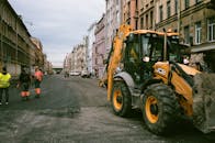 People and construction truck on a street between buildings