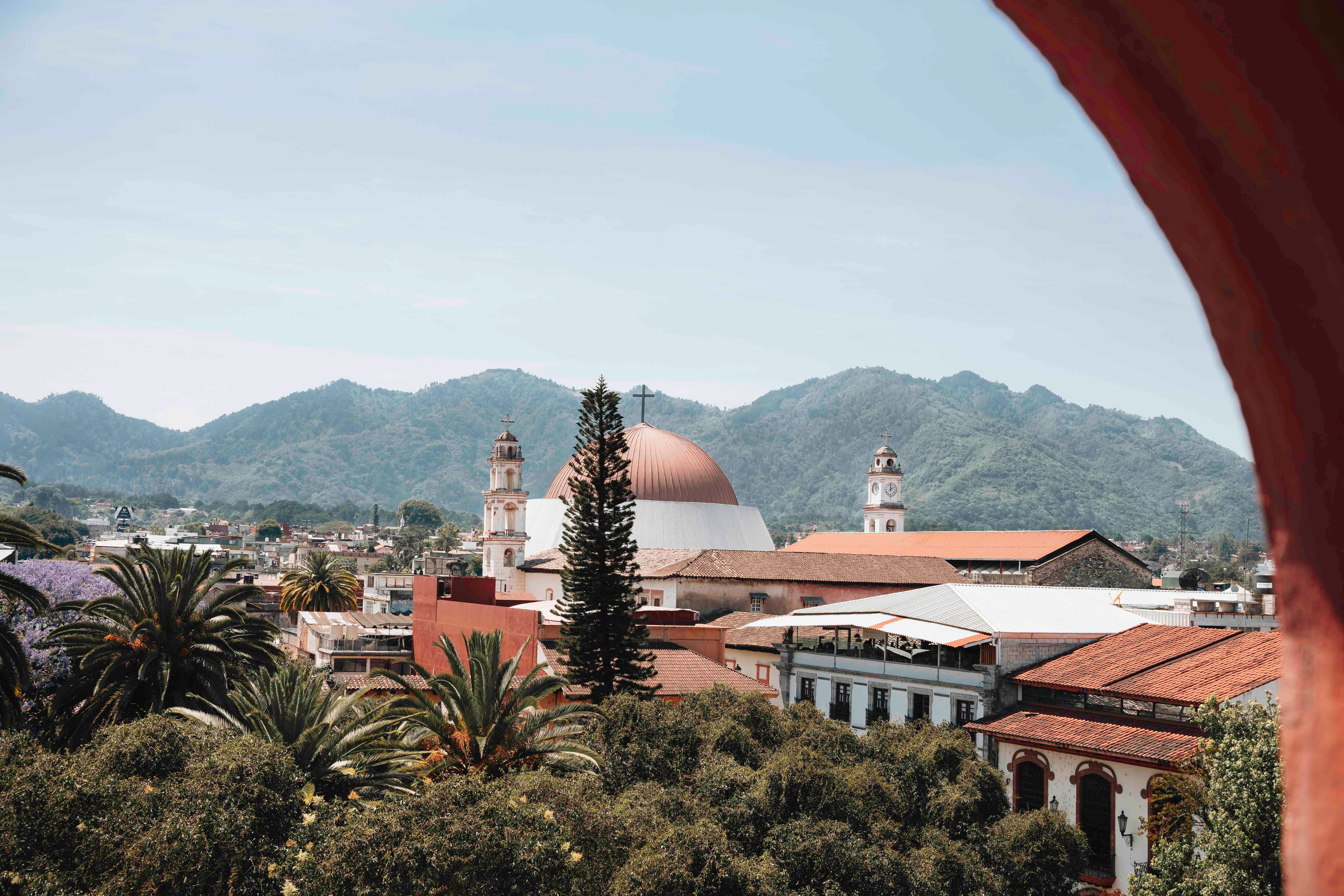 A church and mountains behind a Mexican town.