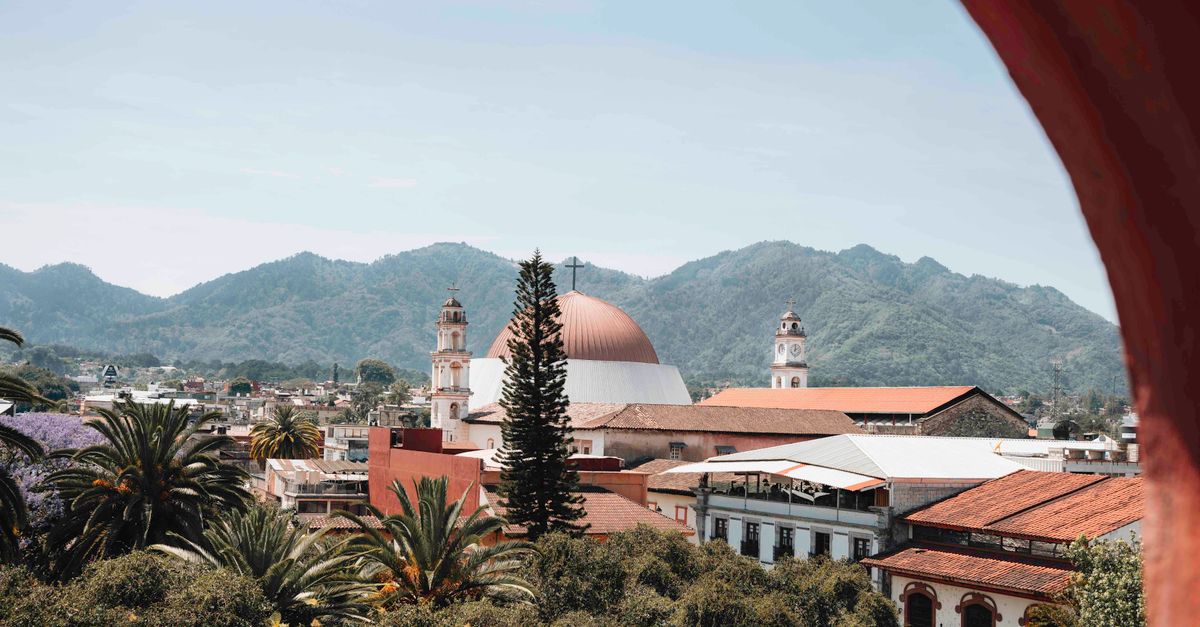 A church and mountains behind a Mexican town.