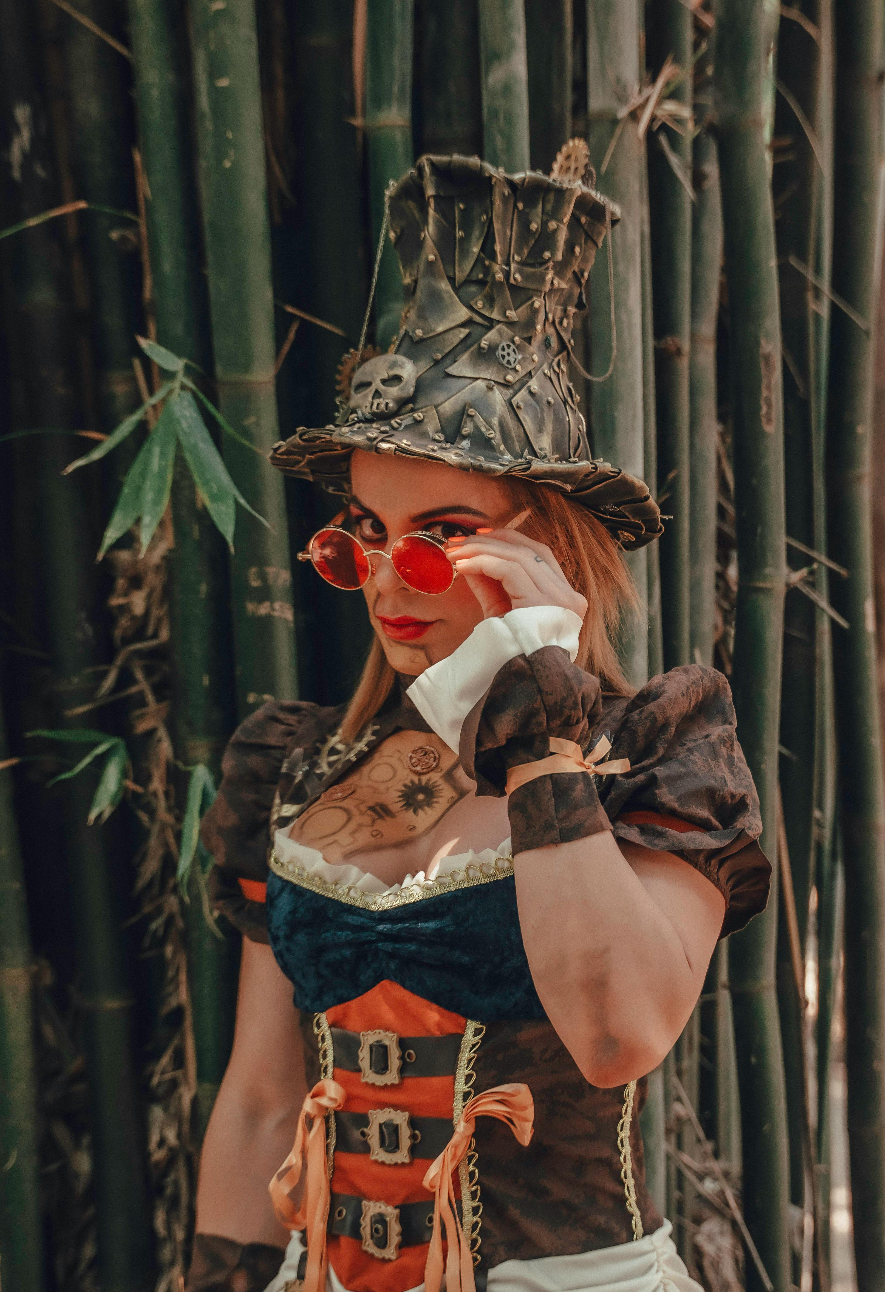 Steampunk cosplay portrait of a young woman with a top hat in a bamboo forest.