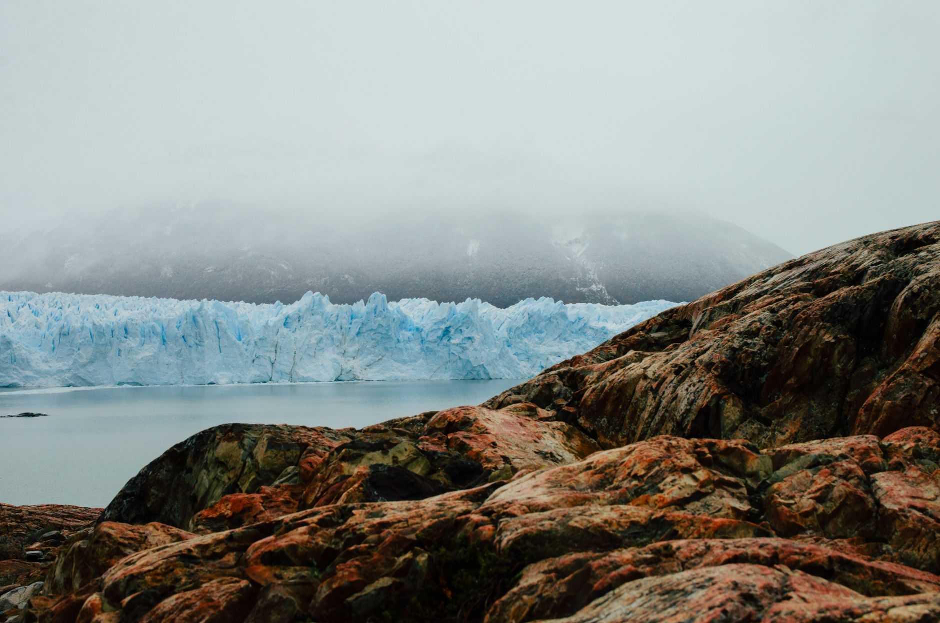 A breathtaking view of the Perito Moreno Glacier in Argentina surrounded by rocky landscape and misty atmosphere.