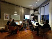 在现代办公环境中，多元化的团队通过笔记本电脑和演示屏幕进行协作