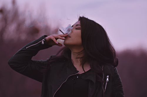 Fotobanka s bezplatnými fotkami na tému čierna kožená bunda, čierny vrch, cigareta