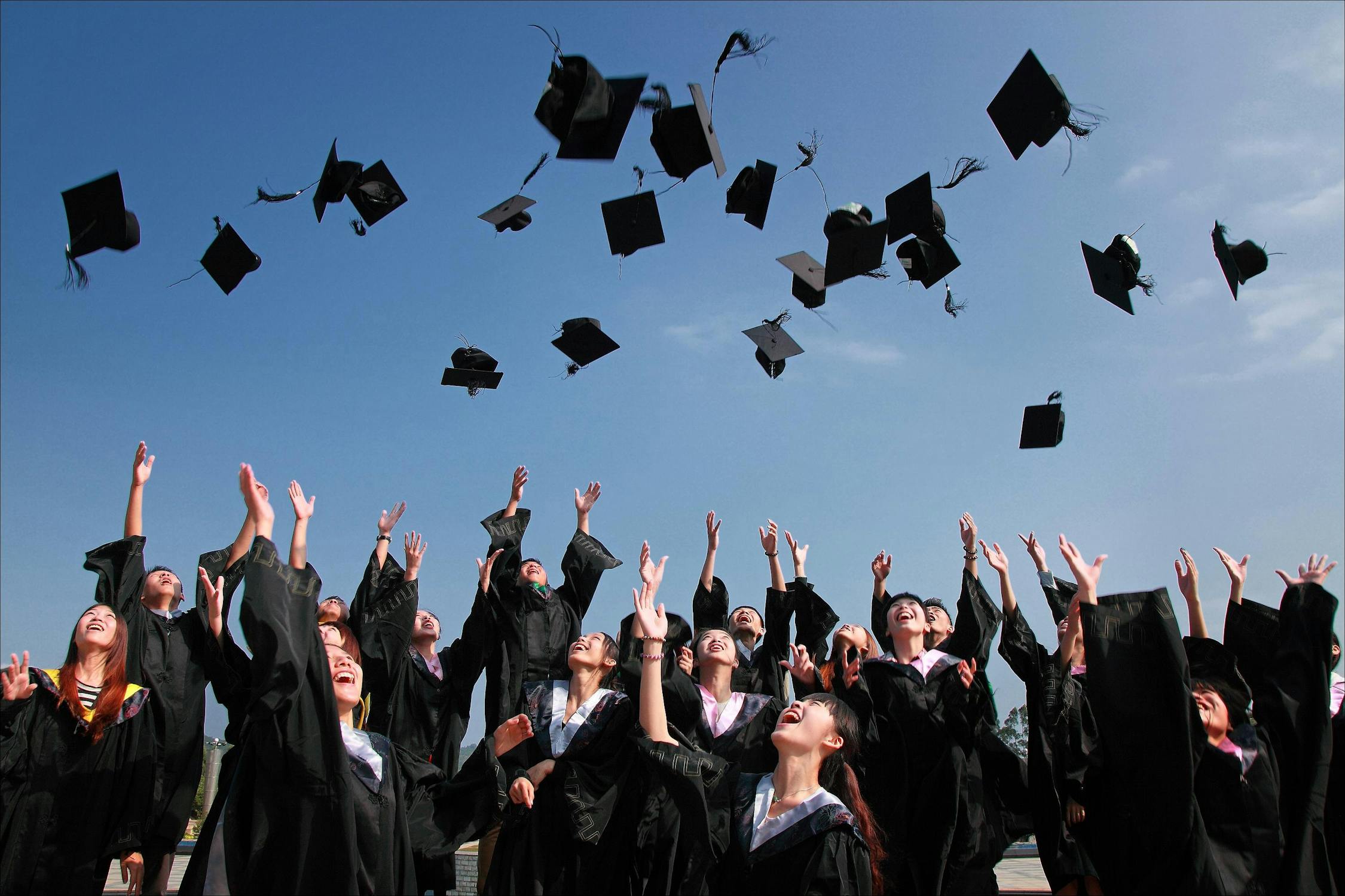 Picture of students throwing graduation caps in the air