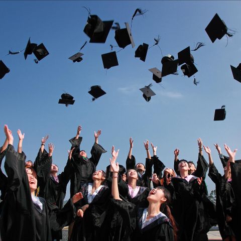 Graduates throwing caps in the air — college students