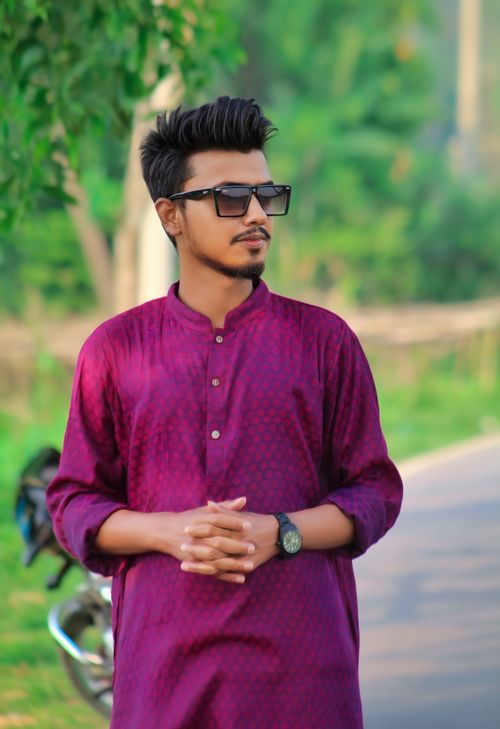 Free A man in a purple traditional outfit wearing sunglasses, posing outdoors. Stock Photo