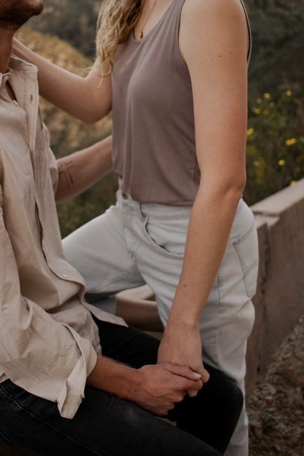 Close-up image of a couple holding hands, capturing intimacy in an outdoor setting.