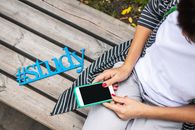Person Sits on Bench Holding Phone