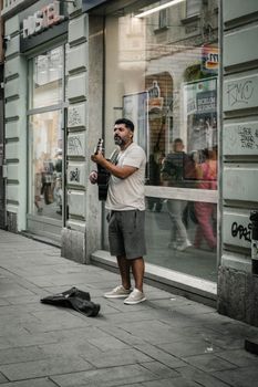 Urban street performer with guitar in Sarajevo, Bosnia and Herzegovina. Capturing musical culture.