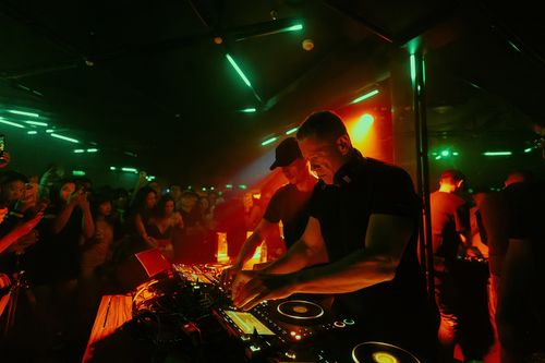 Free Exciting DJ performance in a crowded nightclub, capturing vibrant nightlife energy. Stock Photo