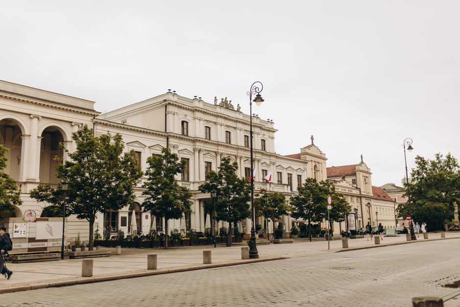 A view of Polonia House on a quiet street in Warsaw, Poland, showcasing historic architecture.