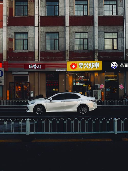 Free White car parked on urban street in Tianjin, China outside local shops. Stock Photo