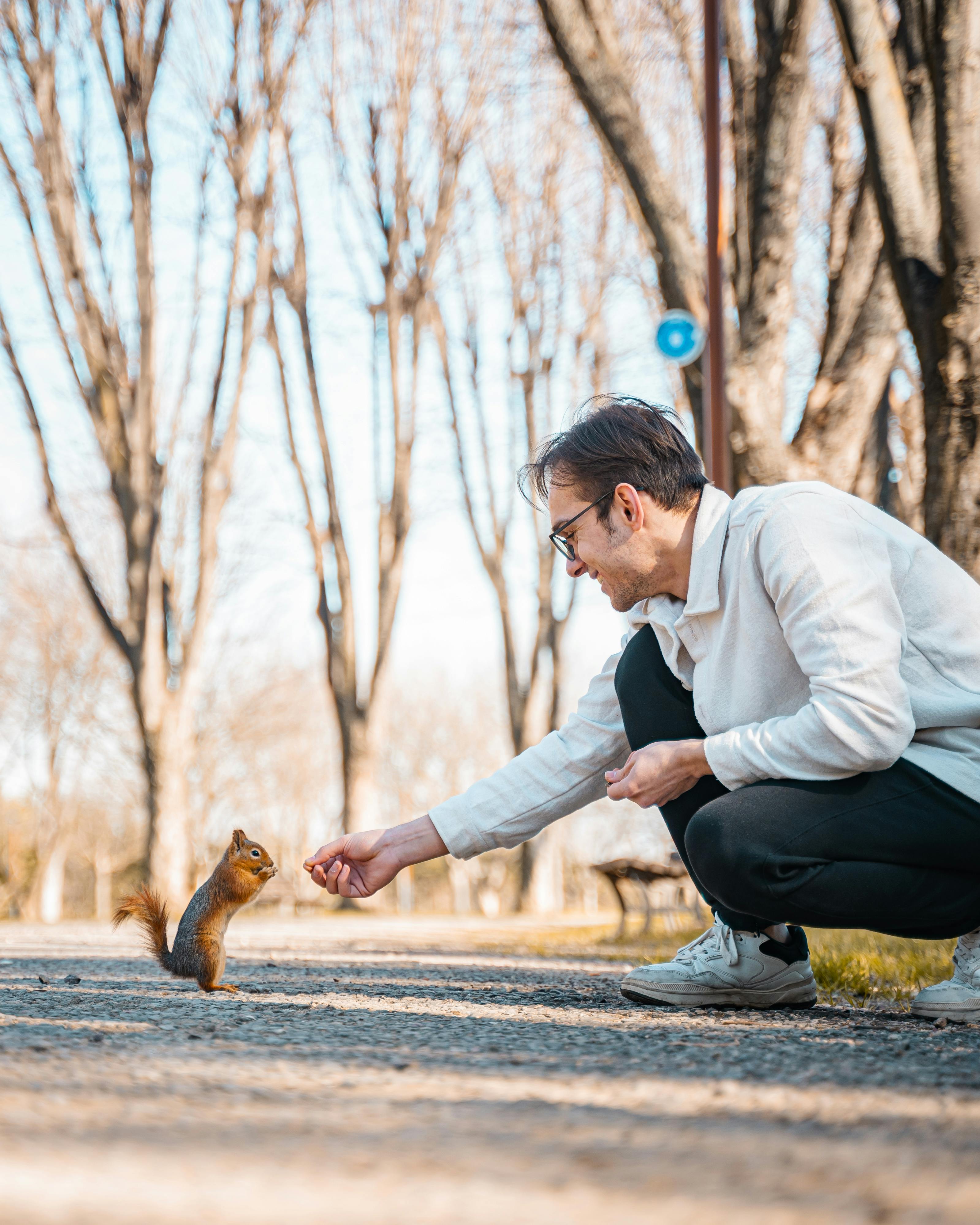 a man feeding a squirrel