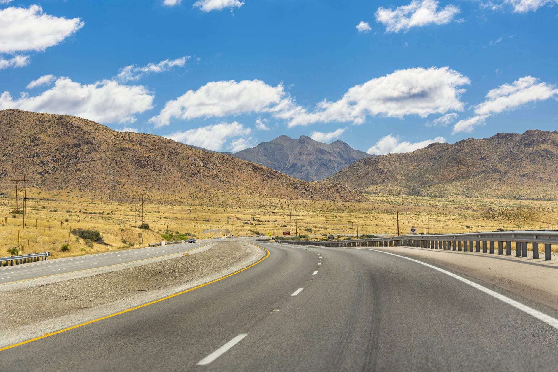 Explore the picturesque highway winding through the mountains in El Paso, Texas, under a vibrant sky.