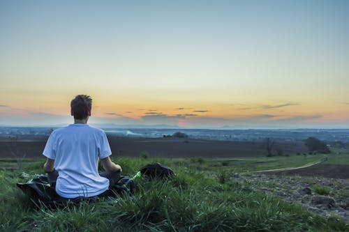 Man Sitting on Grass Field