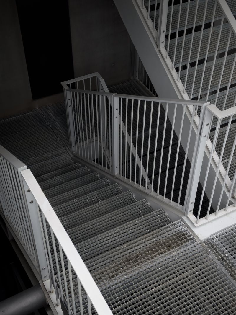 Escada metálica industrial com degraus em chapa e guarda-corpo