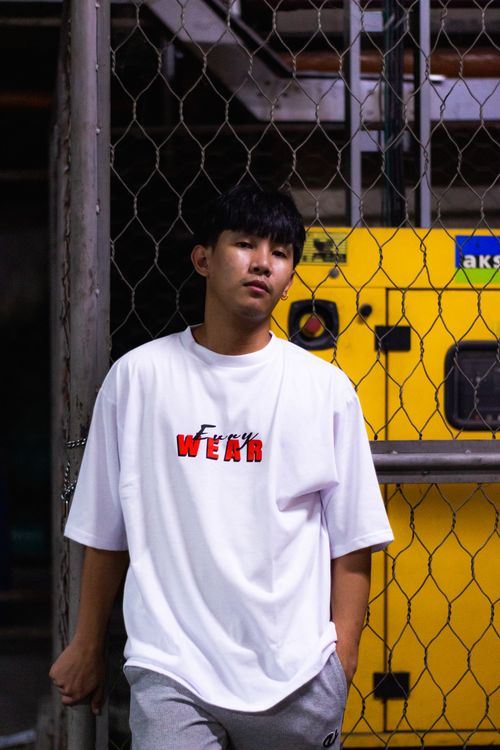 Free Young man in a white t-shirt posing casually indoors with industrial backdrop. Stock Photo