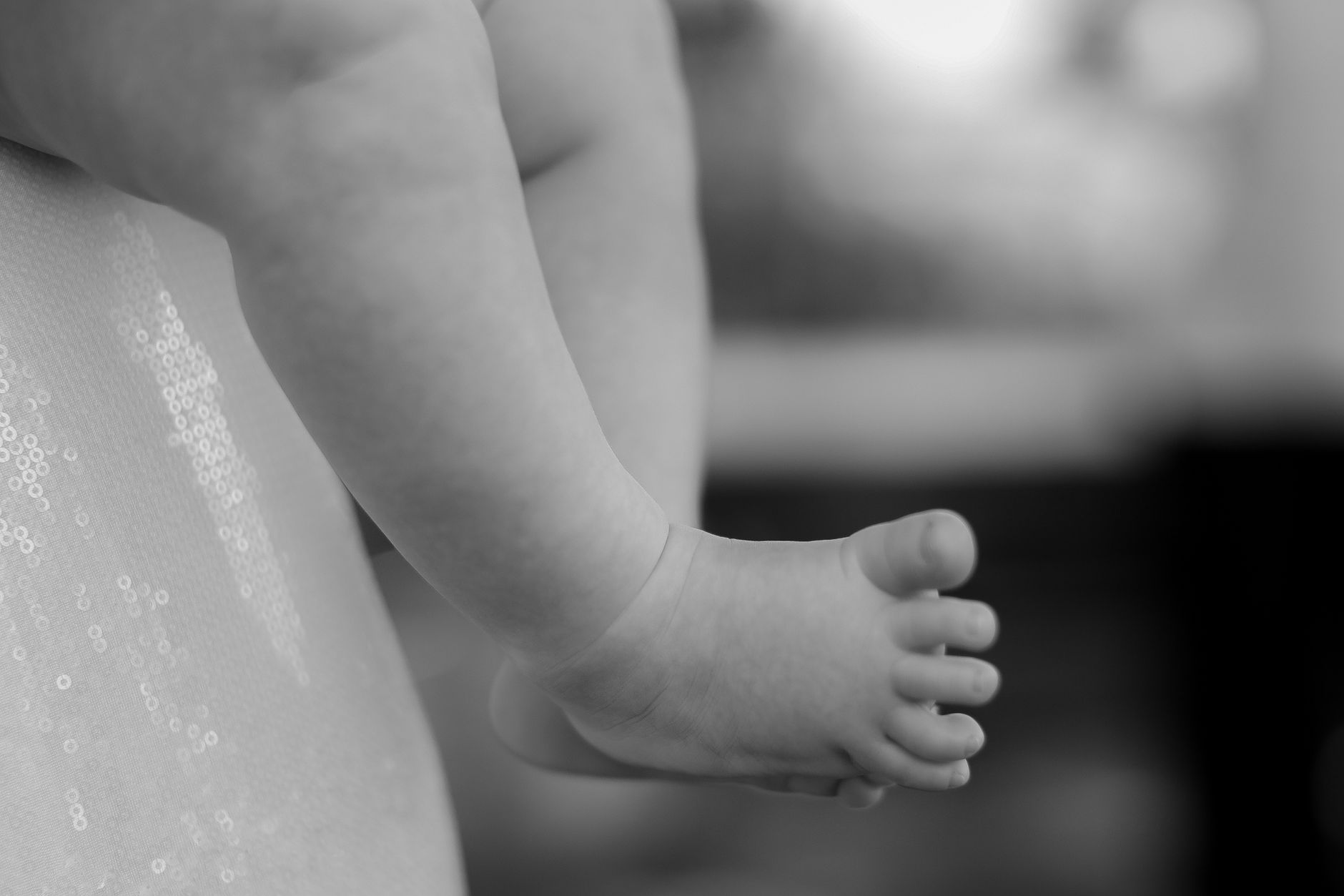 Artistic black and white close-up of a baby's foot, capturing innocence and detail.