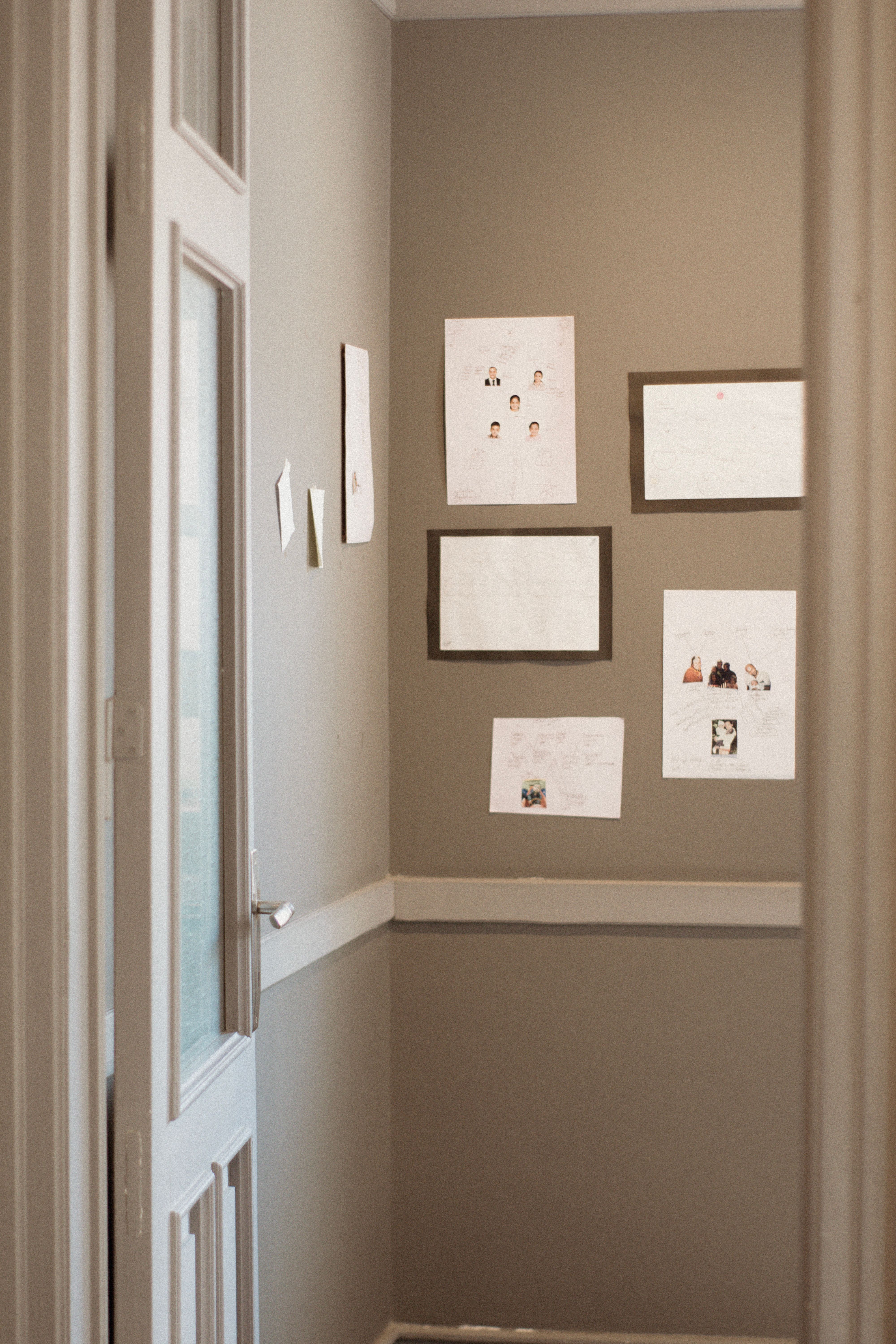 A cozy indoor hallway featuring framed photographs and art on neutral walls.