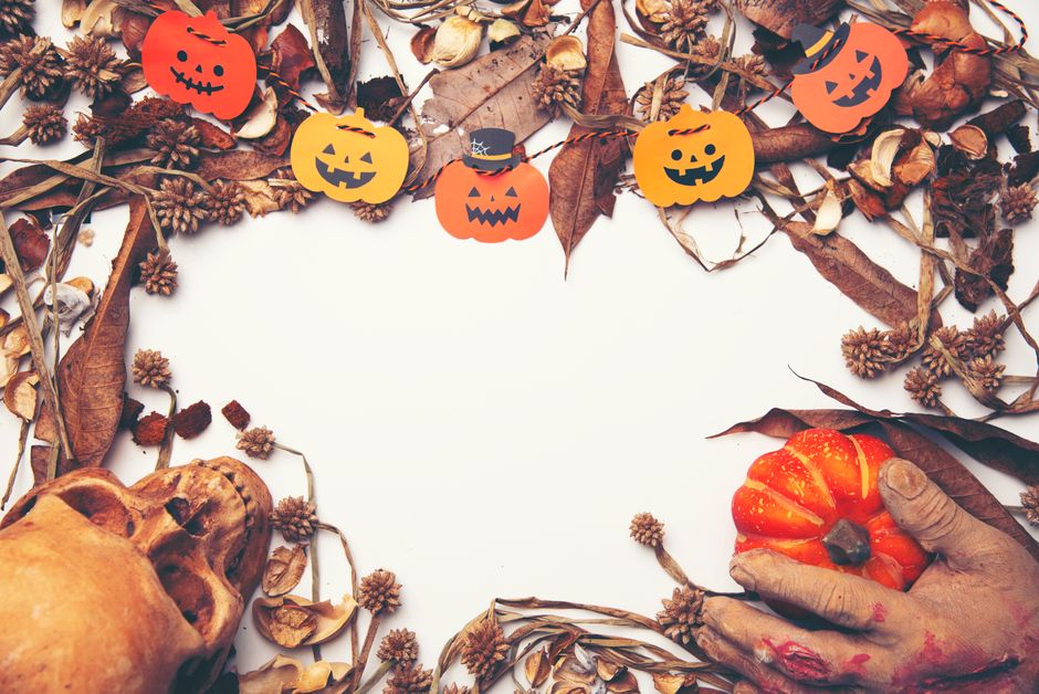 Spooky Halloween design featuring pumpkins, skull, and autumn leaves with copy space.
