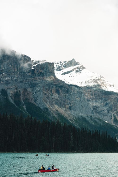 Free Peaceful canoeing on Emerald Lake in Field, BC with snow-capped mountains in the background. Stock Photo