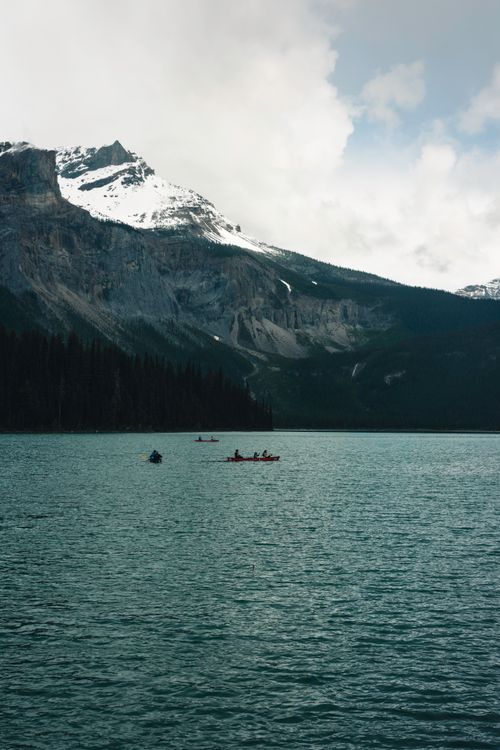 Free People boating on Emerald Lake against majestic mountains in Field, BC, Canada. Stock Photo