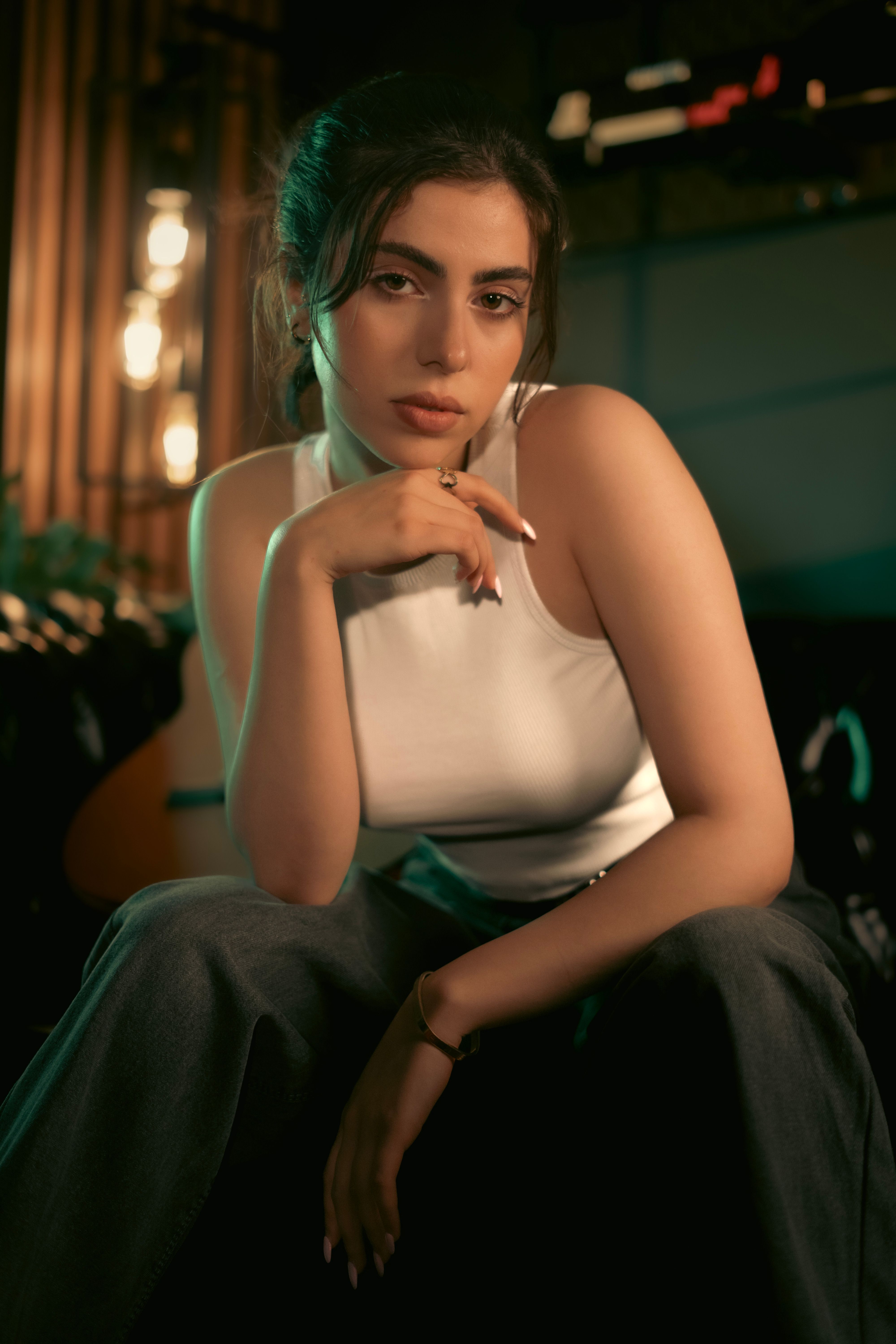 Portrait of a fashionable woman in a modern setting, sitting confidently indoors.
