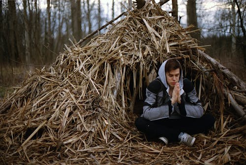 Man Sitting in Front of Hut