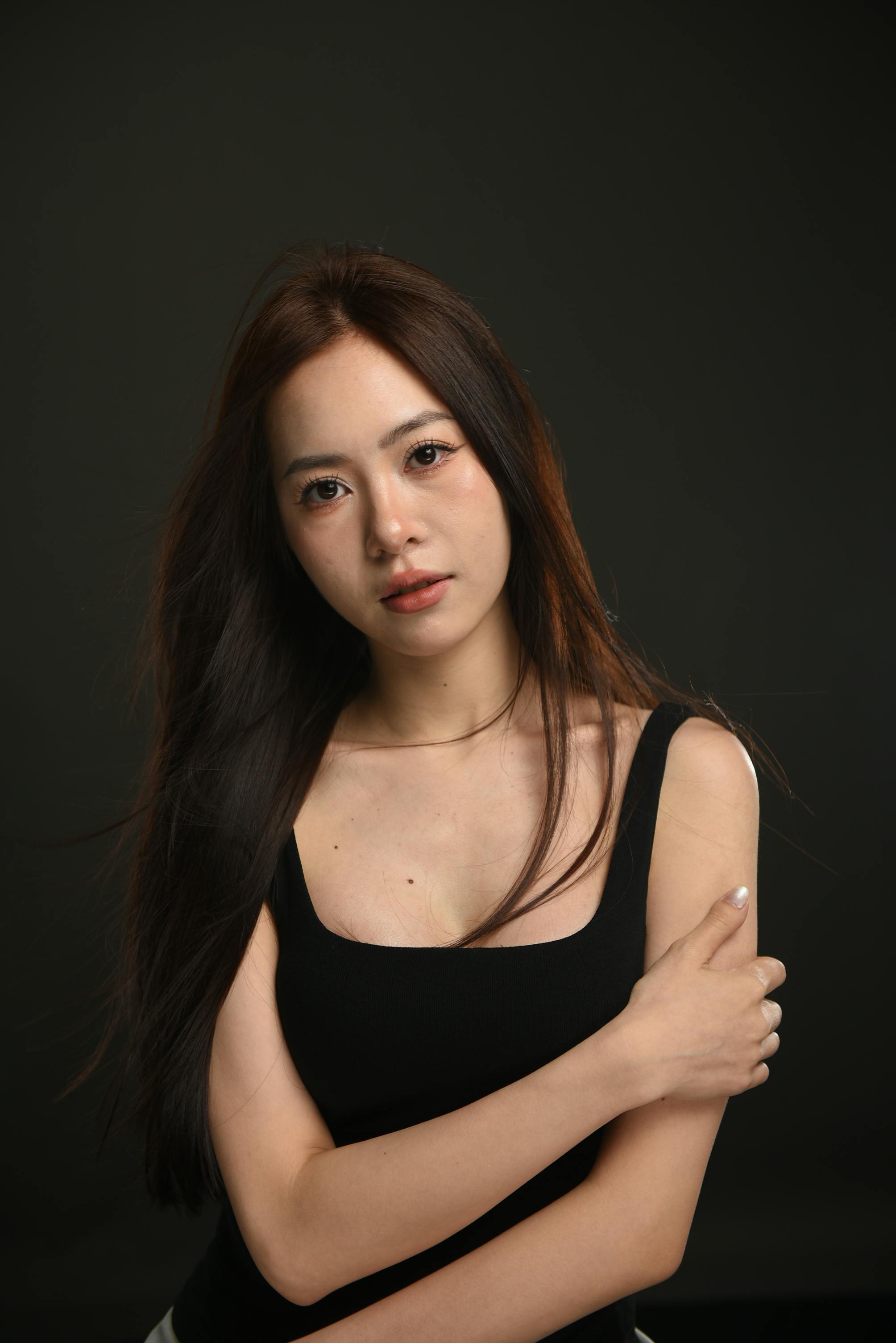 Graceful portrait of an Asian woman with long hair in a studio setting. Perfect for fashion or beauty theme.