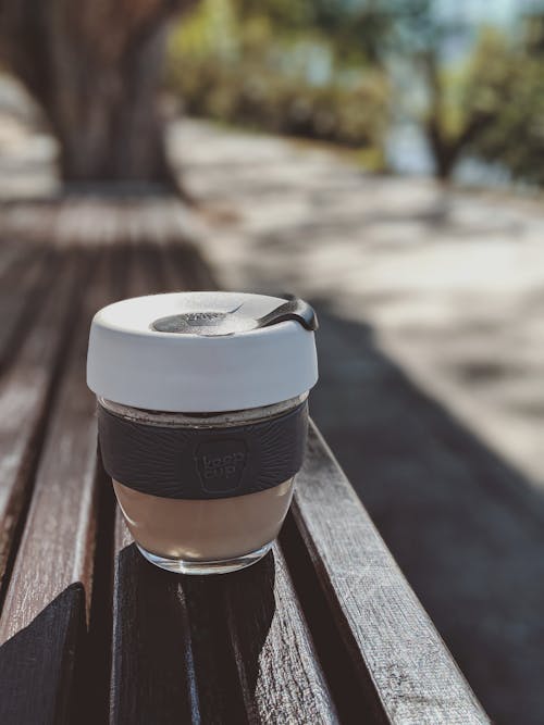 Photo Of Glass Container On Top Of Wooden Bench