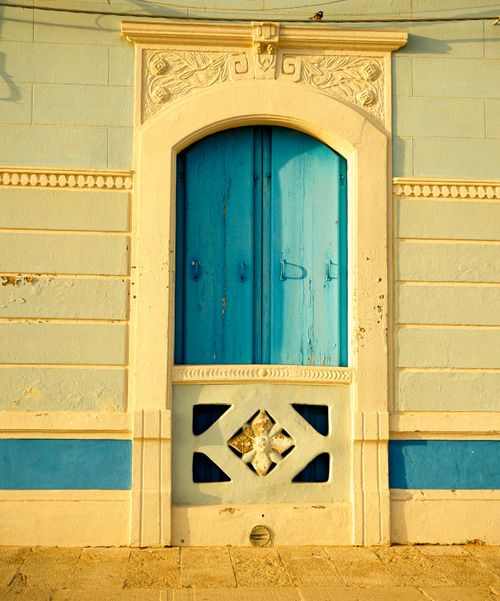 Free Sicilian architecture featuring a blue door and ornate arch. Perfect for travel and architecture collections. Stock Photo