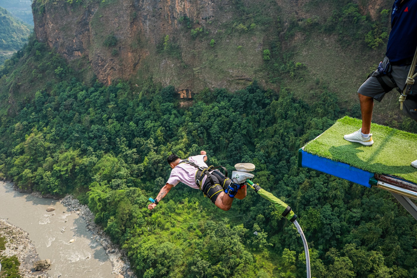 Person bungee jumping over a gorge
