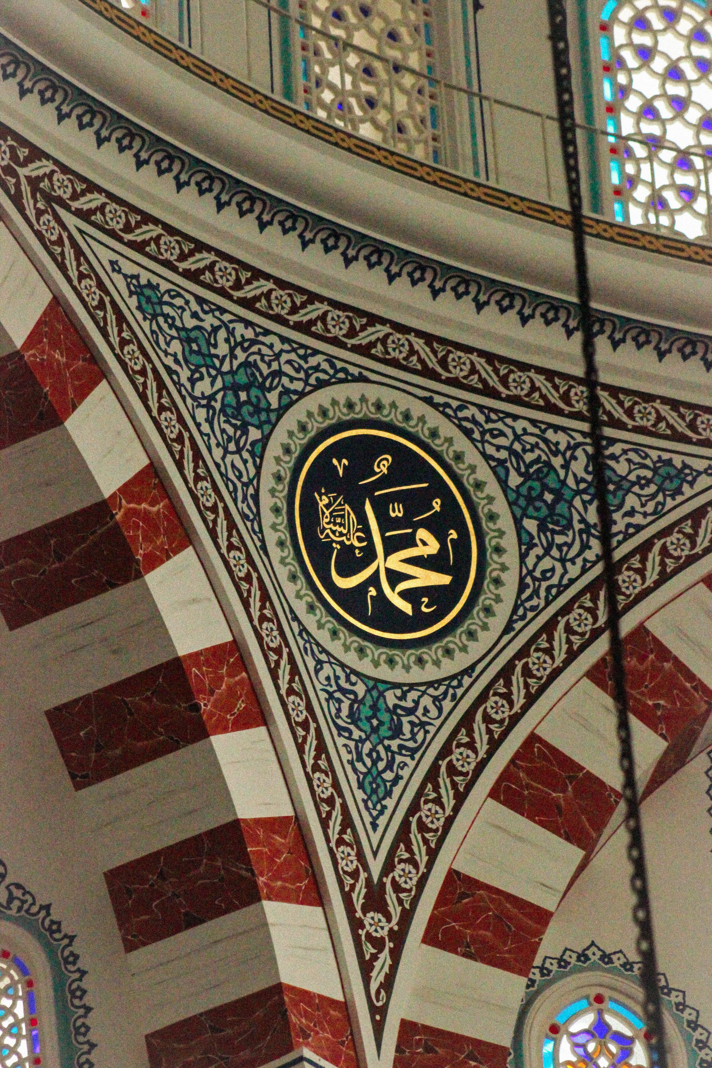 A mosque with ornate arabic writing on the ceiling · Free Stock Photo