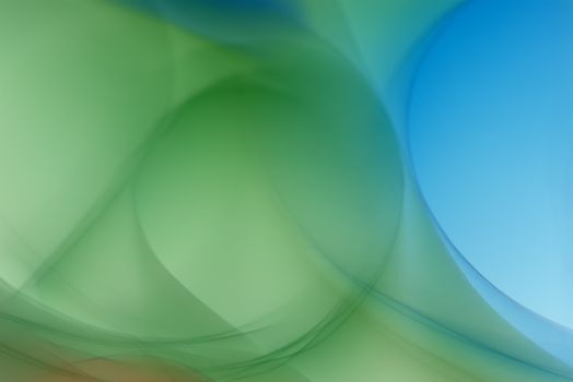 Vibrant abstract background featuring green and blue light swirls.