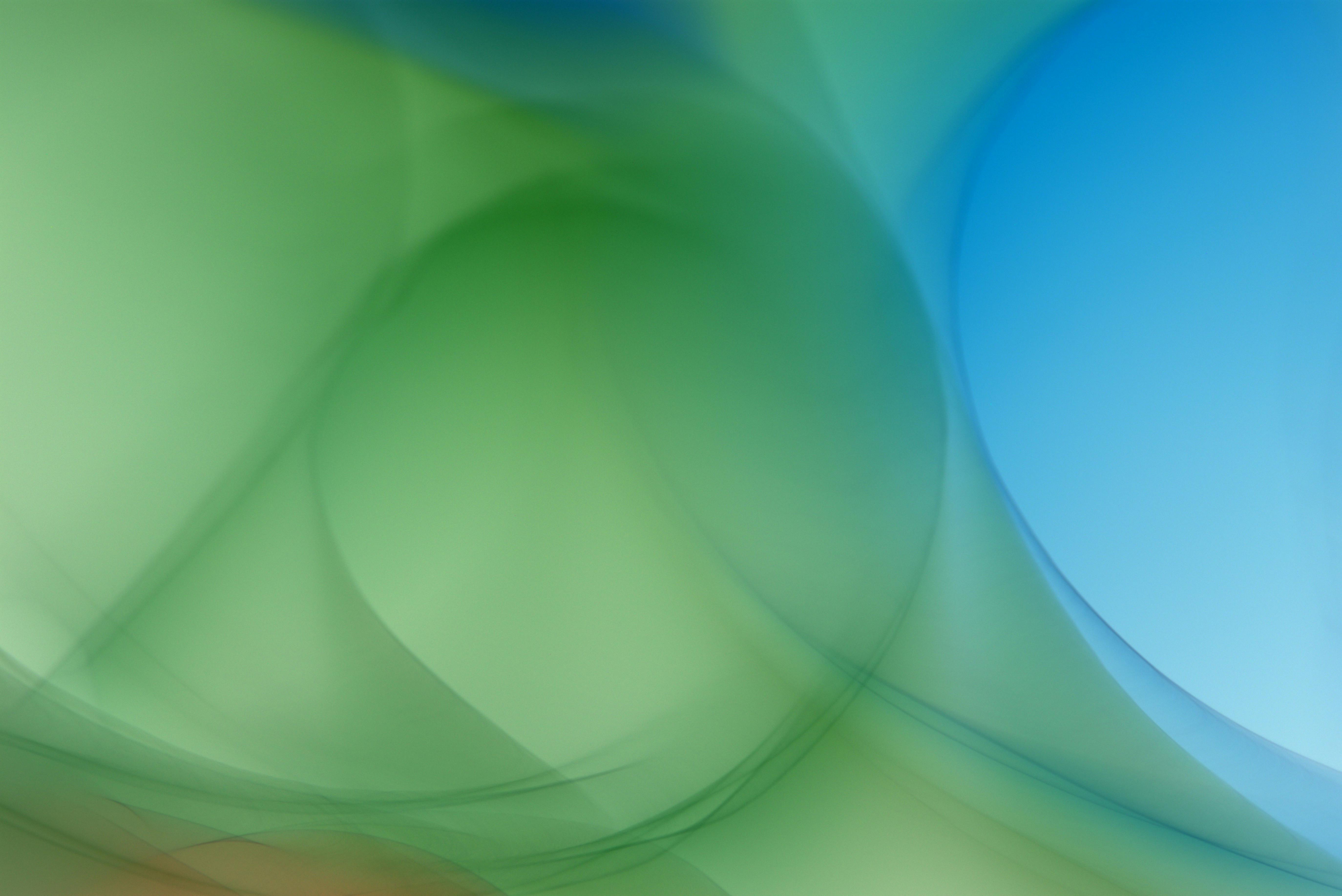 Free Vibrant abstract background featuring green and blue light swirls. Stock Photo