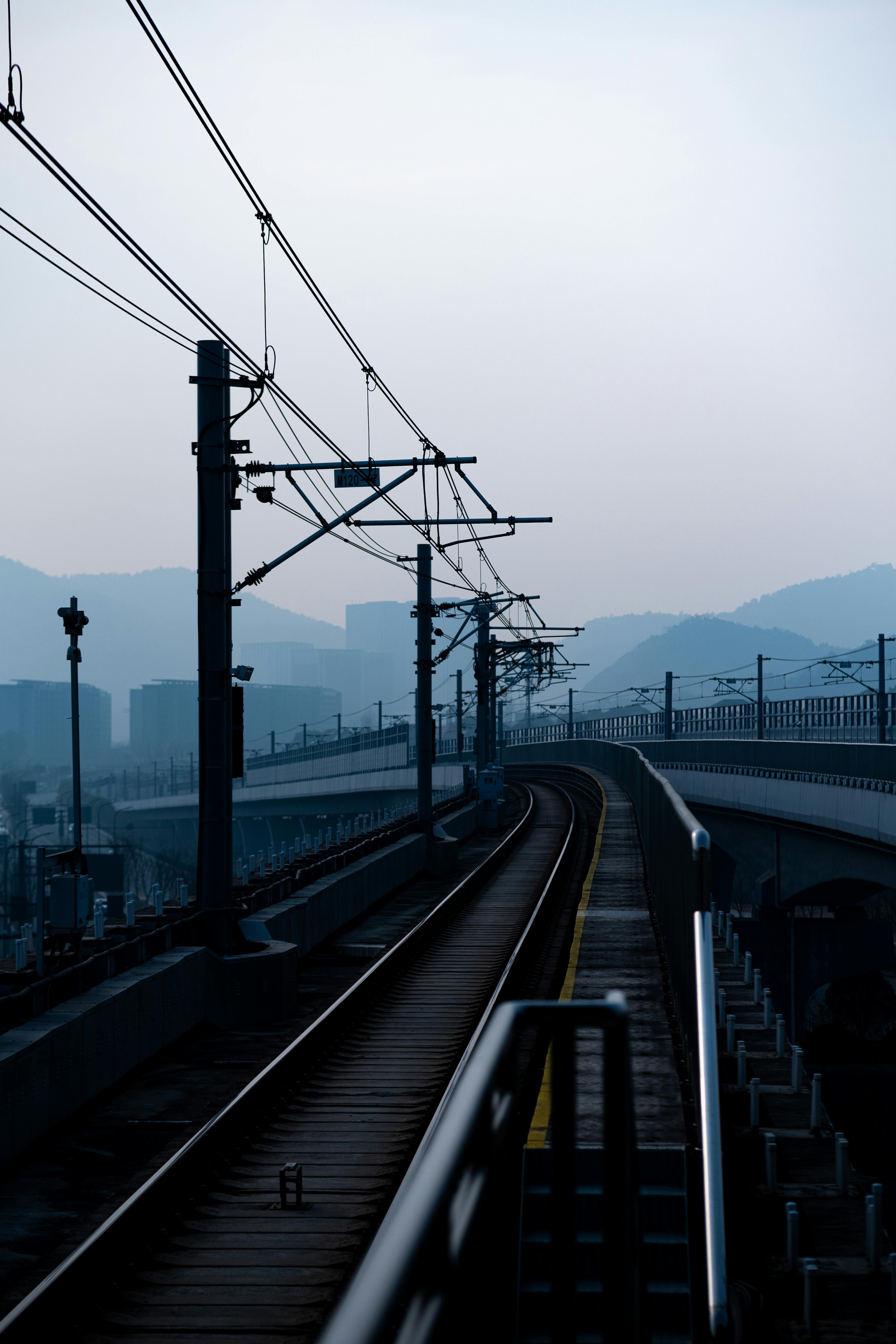 Railway tracks disappearing into a foggy horizon create a serene and mysterious atmosphere.