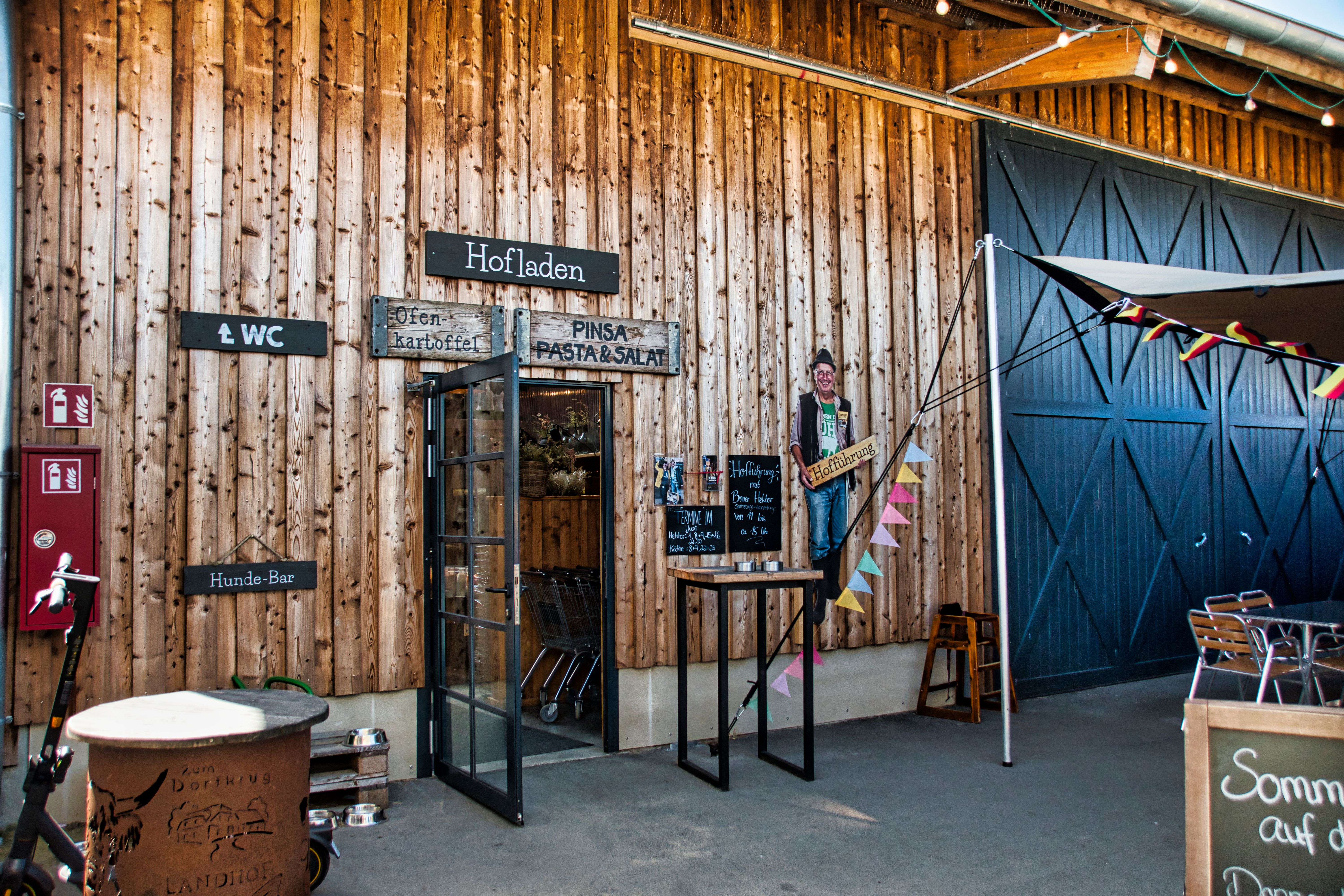 Charming farm shop entrance with wooden facade and decorative signs.