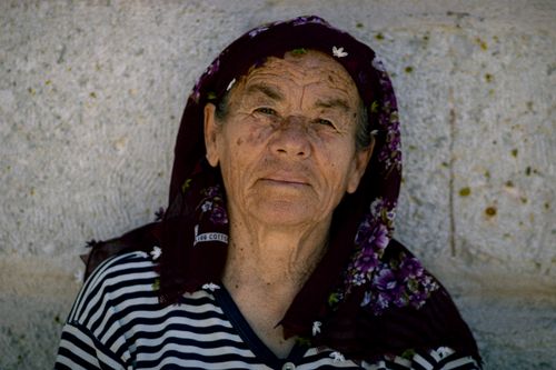 Free Close-up portrait of a senior woman wearing a floral headscarf, exuding traditional charm. Stock Photo