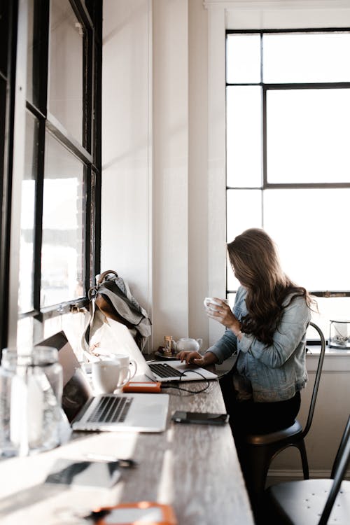 Vrouw In Grijze Jas Zitten Naast Bureau